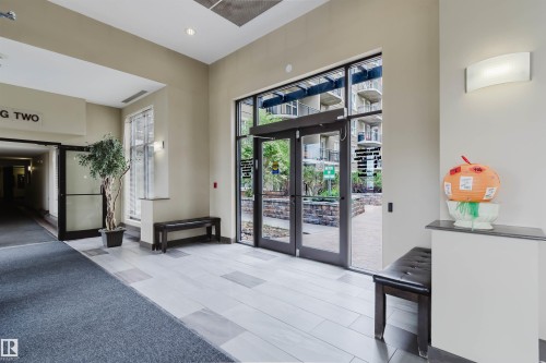 Expansive entry with multi-toned tile flooring, direct access to an outdoor area, a large window, and wall-mounted lighting - #1-405 4245 139 Av Nw, Edmonton, AB 