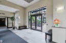 Expansive entry with multi-toned tile flooring, direct access to an outdoor area, a large window, and wall-mounted lighting - #1-405 4245 139 Av Nw, Edmonton, AB 