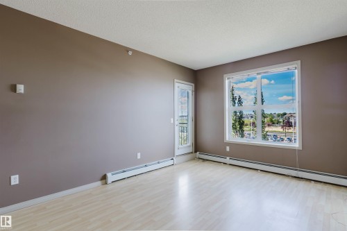 Light wood-finish flooring with neutral wall paint - #1-405 4245 139 Av Nw, Edmonton, AB 