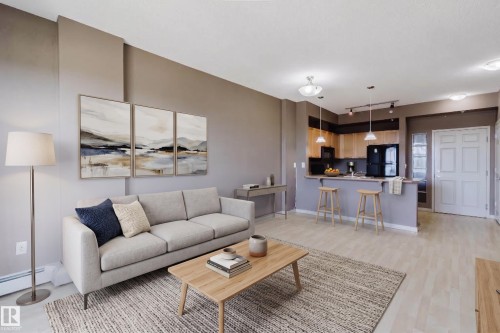 Open-concept living space with light-toned walls and wood-finish flooring - #1-405 4245 139 Av Nw, Edmonton, AB 