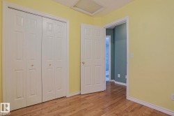 Wood-finish flooring, paneled bifold closet doors, and a paneled interior door - 