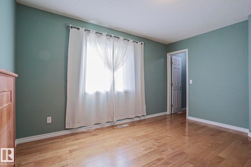 Wood-finish flooring with light wall paint and white trim - 15031 135 Street Nw, Edmonton, AB 