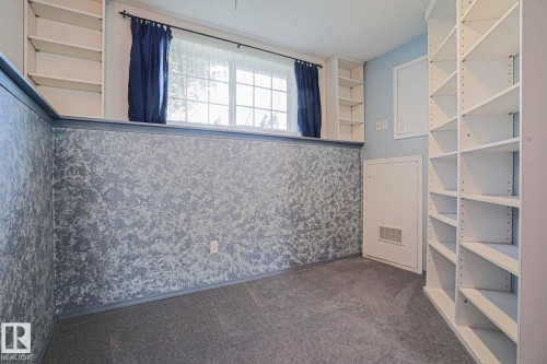 Built-in shelving, multi-pane window, carpet flooring, and a textured wall finish - 15031 135 Street Nw, Edmonton, AB 