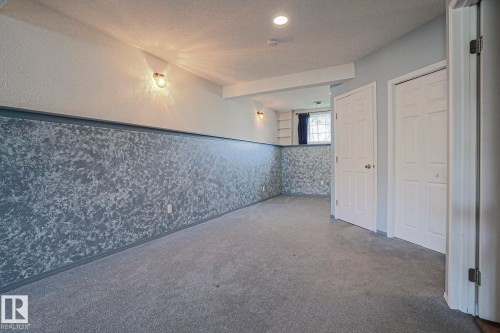 Recessed lighting and wall-mounted fixtures illuminate the space - 15031 135 Street Nw, Edmonton, AB 