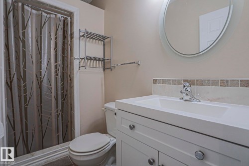 White vanity with integrated sink, chrome faucet, and tiled backsplash - 15031 135 Street Nw, Edmonton, AB 