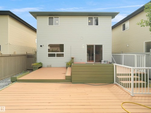 Multi-level wood deck with white railings and an integrated planter box - 2410 32B Street Nw, Edmonton, AB 