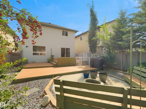 Multi-level deck with wood-finish flooring, sliding glass door, and a concrete patio area - 2410 32B Street Nw, Edmonton, AB 