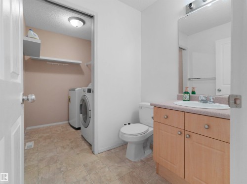 Hard surface flooring, light wood-finish cabinetry, and a full vanity mirror - 2410 32B Street Nw, Edmonton, AB 