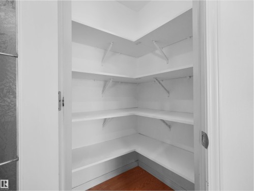 White-painted interior closet with multiple built-in corner shelves - 2410 32B Street Nw, Edmonton, AB 