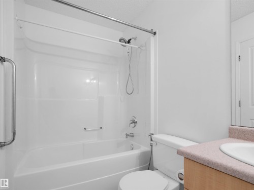 Full white tub and shower combination with chrome fixtures - 2410 32B Street Nw, Edmonton, AB 