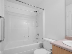 Full white tub and shower combination with chrome fixtures - 