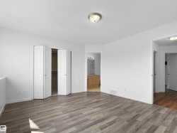 Wood-finish flooring, white bifold closet doors, and recessed lighting - 