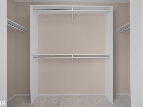 Built-in shelving with two hanging rods and upper storage - 2410 32B Street Nw, Edmonton, AB 
