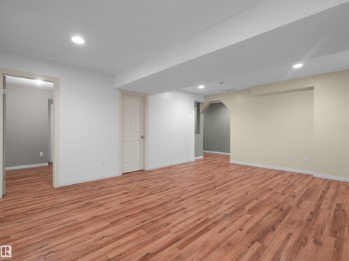 Open-concept room featuring wood-finish flooring, recessed lighting, and neutral wall tones - 2410 32B Street Nw, Edmonton, AB 