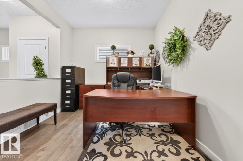 Dedicated office space featuring wood-finish flooring, half-wall separation, and natural light from horizontal windows - 2709 Collins Crescent Sw Sw, Edmonton, AB - Indoor Photo Showing Office