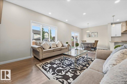Open-concept living space featuring wood-finish flooring, recessed lighting, and a neutral color palette - 2709 Collins Crescent Sw Sw, Edmonton, AB - Indoor Photo Showing Living Room