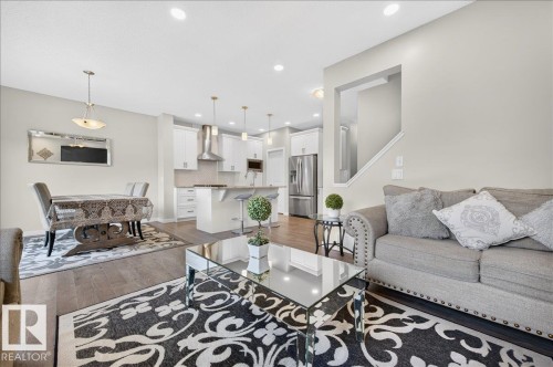 Open-concept living space featuring wood-finish flooring, recessed lighting, and a neutral color palette - 2709 Collins Crescent Sw Sw, Edmonton, AB - Indoor Photo Showing Living Room
