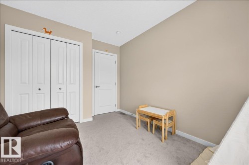 Carpeted room featuring neutral wall paint, white trim, and a white bi-fold closet door - 2709 Collins Crescent Sw Sw, Edmonton, AB - Indoor