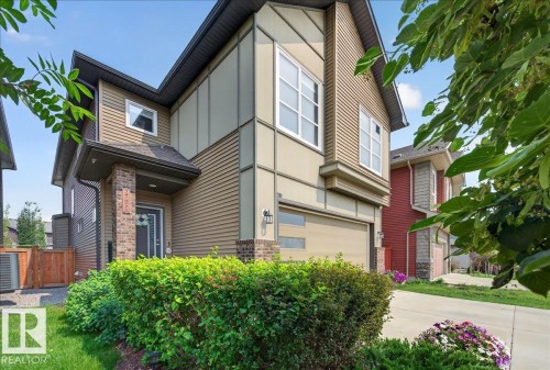Contemporary exterior featuring mixed siding, a two-story design, an attached garage, a covered front entry, and mature landscaping - 2709 Collins Crescent Sw Sw, Edmonton, AB - Outdoor