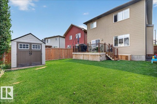 Spacious backyard featuring a substantial lawn, a built-in storage shed, and a privacy fence - 2709 Collins Crescent Sw Sw, Edmonton, AB - Outdoor With Deck Patio Veranda