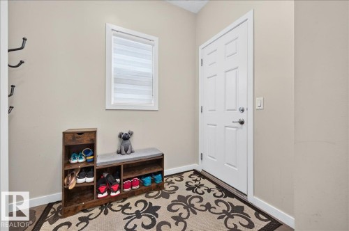 Entryway featuring a paneled door with brushed nickel hardware, light-colored walls, and a window with blinds - 2709 Collins Crescent Sw Sw, Edmonton, AB - Indoor Photo Showing Other Room