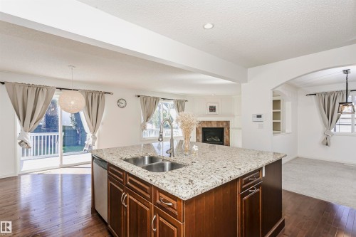 Kitchen island with a granite-style countertop and stainless steel double sink - 2407 Hagen Way Nw, Edmonton, AB 
