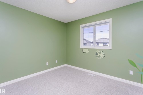 Wall-to-wall carpeting, single window with grid pattern, neutral wall color, and white trim - 2407 Hagen Way Nw, Edmonton, AB 