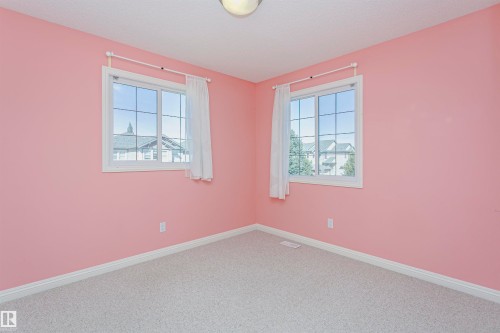 Neutral-toned carpeting, two windows with white trim, and a ceiling-mounted light fixture - 2407 Hagen Way Nw, Edmonton, AB 