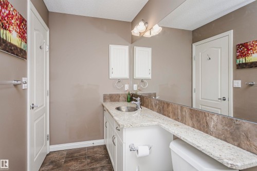 Vanity with an undermount sink, granite countertop, white cabinetry, and a full-width mirror - 2407 Hagen Way Nw, Edmonton, AB 