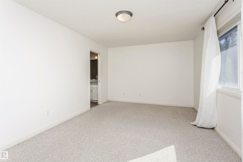 Recessed lighting fixture, light-colored carpet flooring, white walls, window with natural light, interior door to an adjacent space - 2407 Hagen Way Nw, Edmonton, AB 