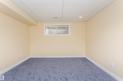 Recessed lighting, drop ceiling, neutral wall color, blue carpet, and white trim - 2407 Hagen Way Nw, Edmonton, AB 