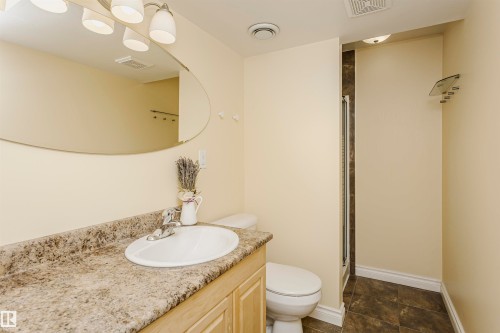 Vanity with an integrated sink, polished chrome faucet, and stone-look countertop - 2407 Hagen Way Nw, Edmonton, AB 