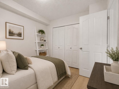 Light wood-finish flooring, white walls, built-in bi-fold closet doors, and white interior doors - #114 12035 22 Av Sw, Edmonton, AB 