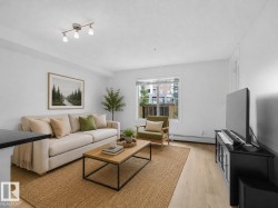 Bright living space featuring track lighting, large window with natural light, and light wood-finish flooring - 