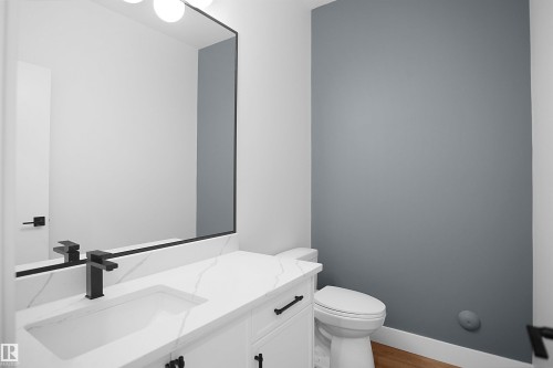 White vanity with an integrated rectangular sink and a matte black faucet - 142 Edgewater Circle, Leduc, AB 