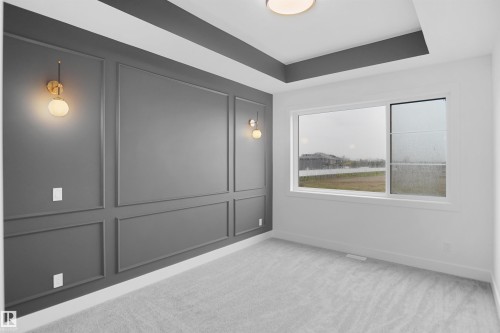 Accent wall featuring applied wall molding and two spherical sconces - 142 Edgewater Circle, Leduc, AB 