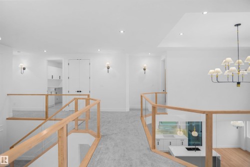 Upper-level landing featuring light wood railings with glass panels, recessed lighting, and sconce lighting - 142 Edgewater Circle, Leduc, AB 