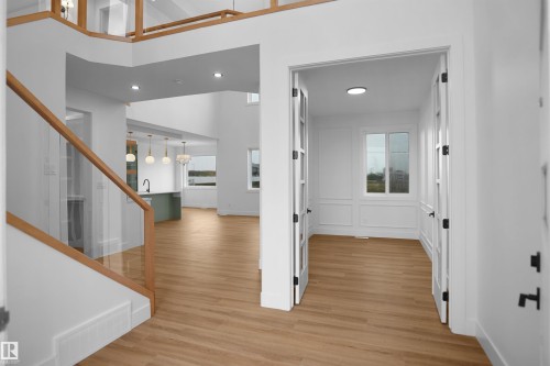 Foyer showcasing wood-finish flooring, a contemporary glass and wood railing, and recessed lighting - 142 Edgewater Circle, Leduc, AB 
