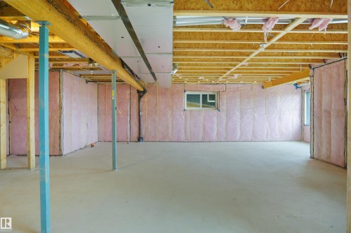 Open lower level with concrete flooring, exposed wood joists, and insulated perimeter walls featuring two windows - 142 Edgewater Circle, Leduc, AB 