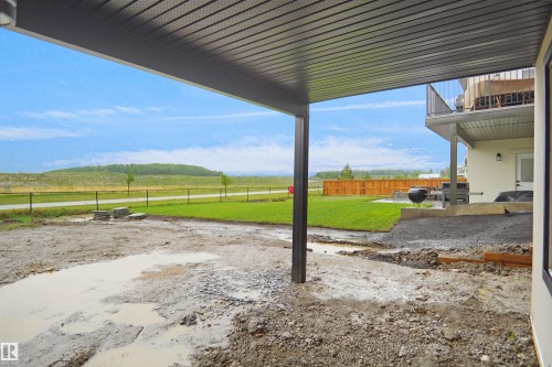 Covered patio space featuring a corrugated metal ceiling and structural post - 142 Edgewater Circle, Leduc, AB 