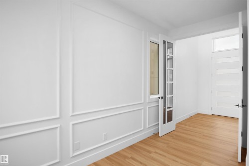 Room featuring decorative wall molding and wood-finish flooring - 142 Edgewater Circle, Leduc, AB 