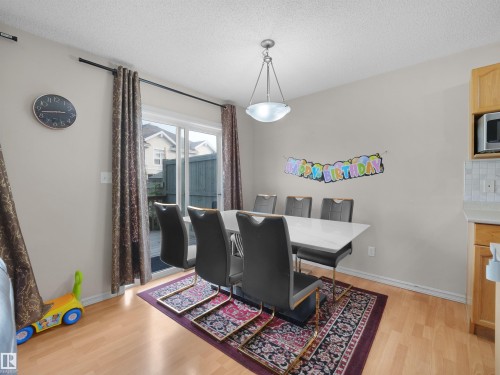 Wood-finish flooring throughout, complemented by a sliding glass patio door - 8111 7 Ave Avenue Sw, Edmonton, AB 