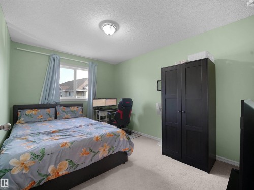 Carpeted room with a single window, a built-in light fixture, and light green wall paint - 8111 7 Ave Avenue Sw, Edmonton, AB 