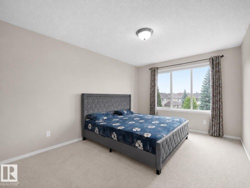 Neutral wall tones with a large window and carpeting - 8111 7 Ave Avenue Sw, Edmonton, AB 