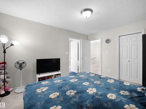Soft gray wall paint with white trim, a flush-mount ceiling light fixture, and white bi-fold closet doors - 8111 7 Ave Avenue Sw, Edmonton, AB 
