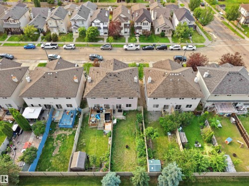 Expansive backyard featuring a lush lawn, established trees, and a storage shed - 8111 7 Ave Avenue Sw, Edmonton, AB 
