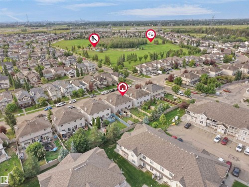 Residential neighborhood featuring detached and attached properties with green spaces and a distant urban skyline - 8111 7 Ave Avenue Sw, Edmonton, AB 