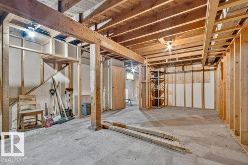 Unfinished basement featuring exposed wood joists, concrete flooring, and partial wall framing - 12705 87 Street Nw, Edmonton, AB 