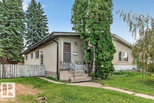 Stucco exterior with a gable roofline, concrete steps, and a wrought iron railing - 12705 87 Street Nw, Edmonton, AB 
