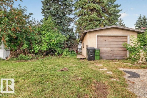 Detached garage with a wood-finish overhead door and stucco exterior - 12705 87 Street Nw, Edmonton, AB 